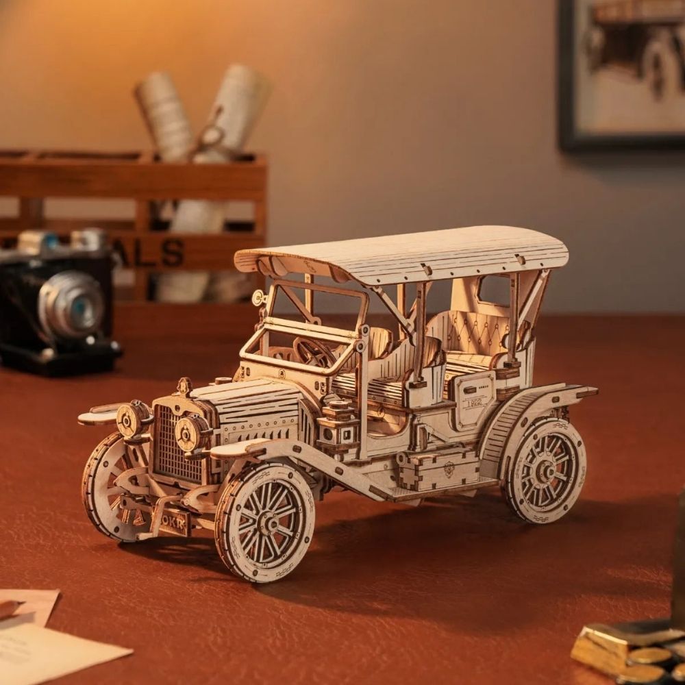 Wooden model of an old-fashioned car on a wooden surface with a blurred background