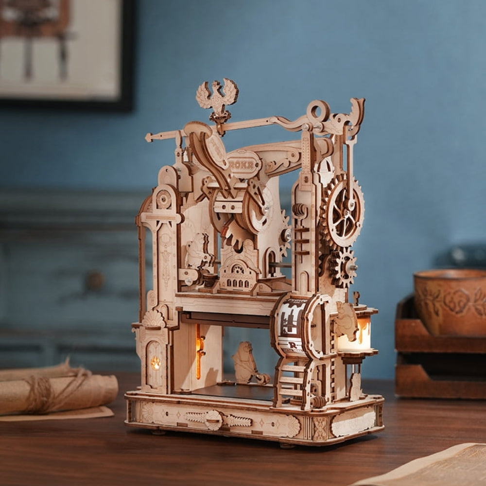 Wooden mechanical model with gears and lights on a wooden table