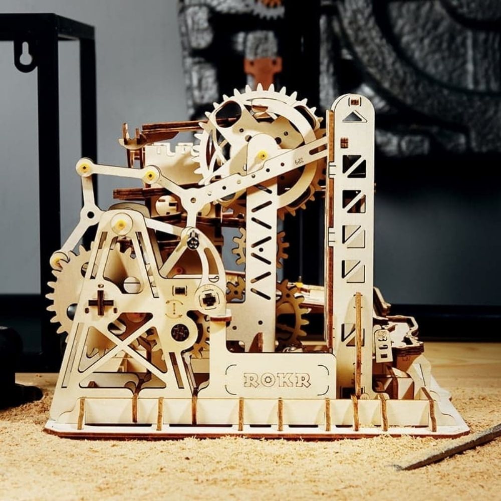 Mechanical model kit with gears and ROKR branding on a wooden surface.