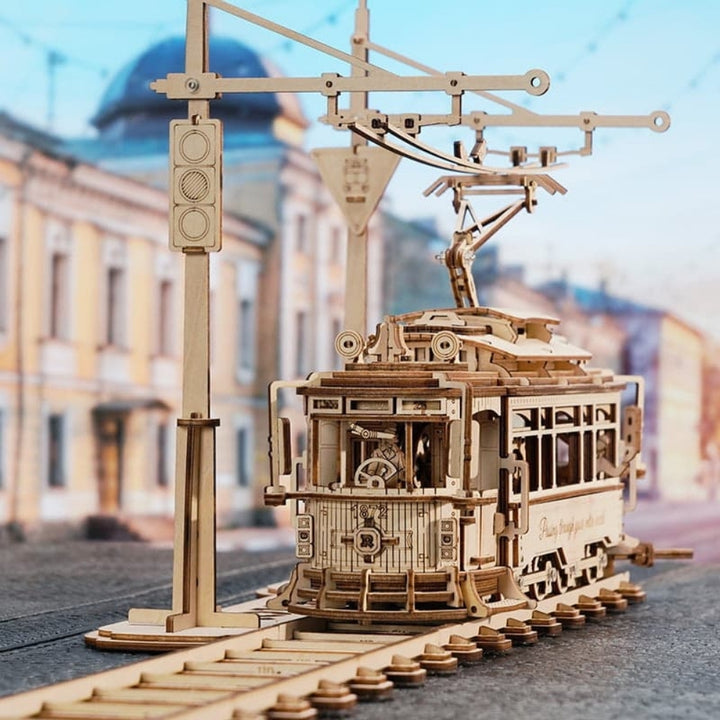 Wooden model of a tram on a street with buildings in the background