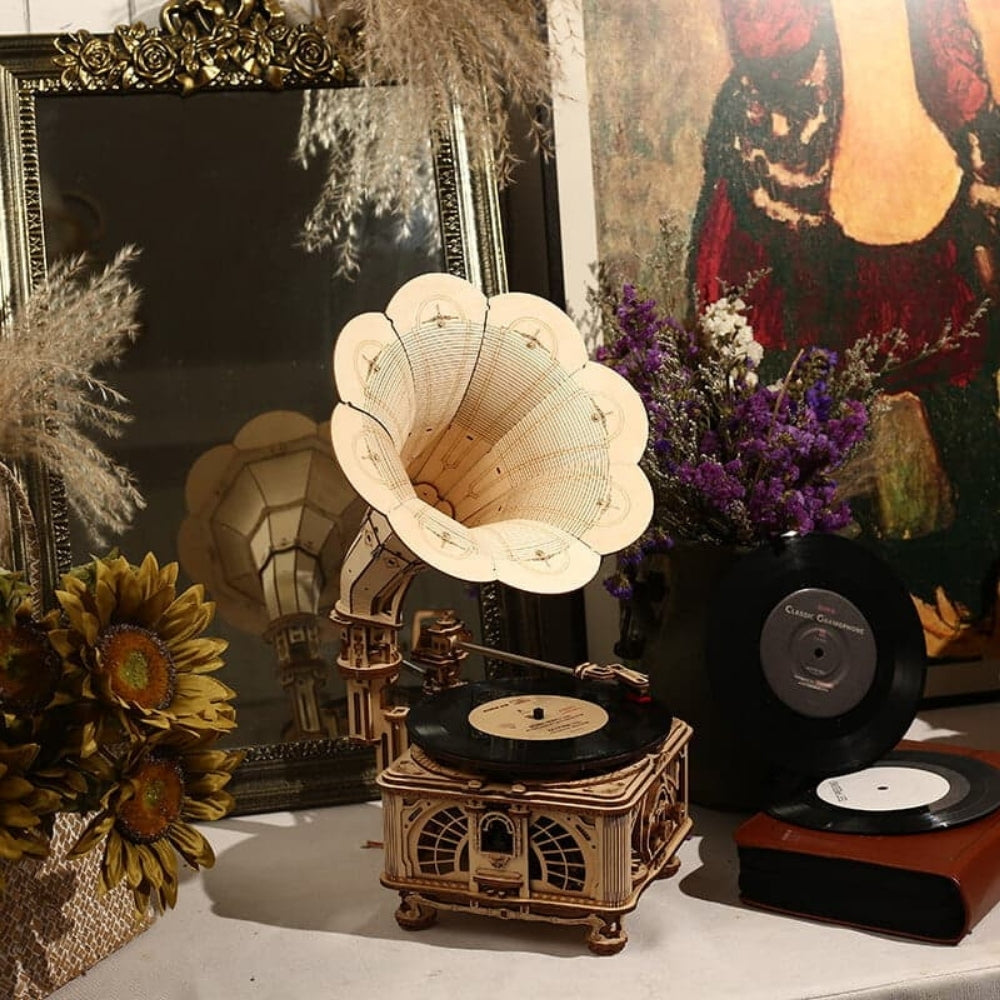 Vintage-style gramophone with vinyl records on a decorative surface with flowers and a mirror.