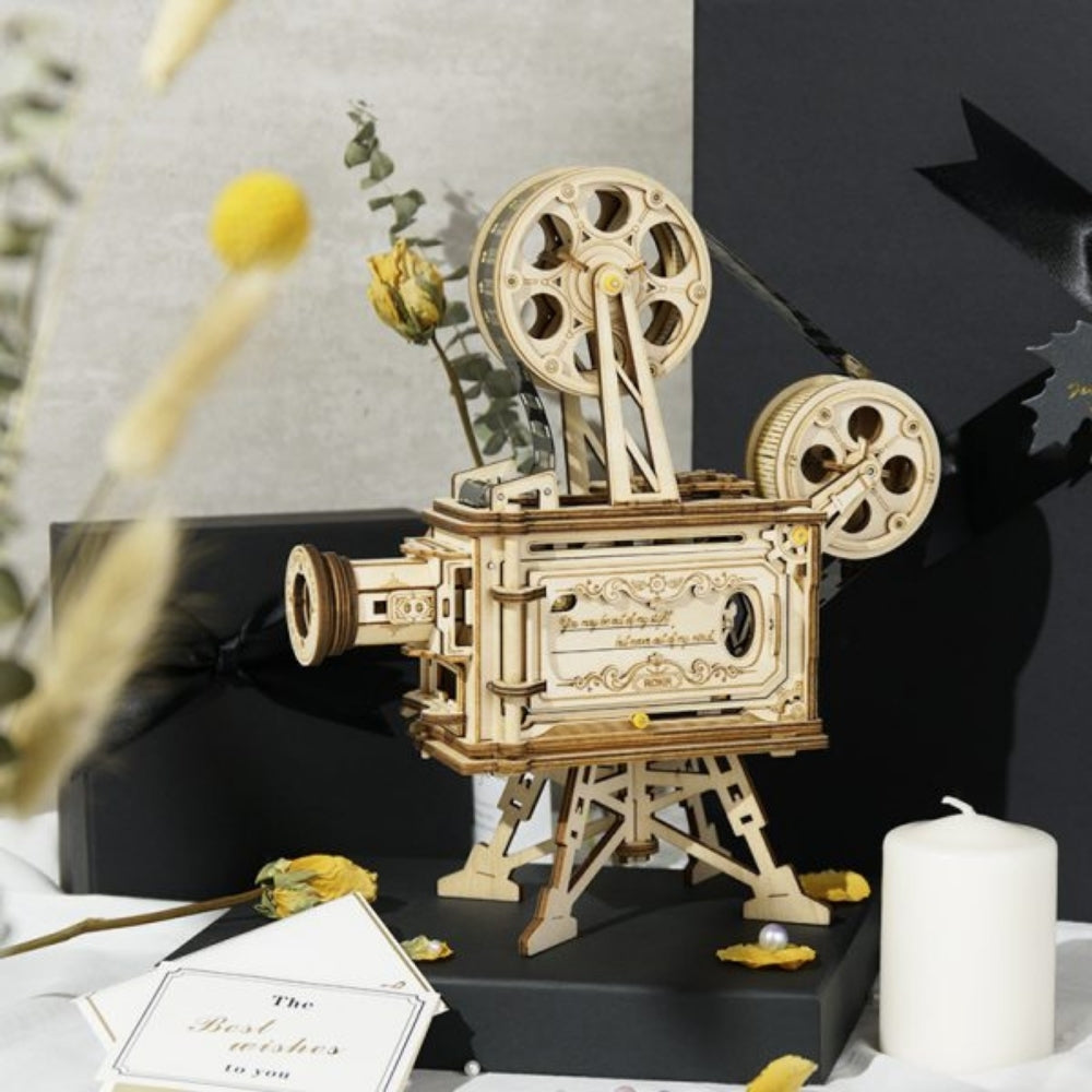 Wooden movie projector model on a black base with decorative elements