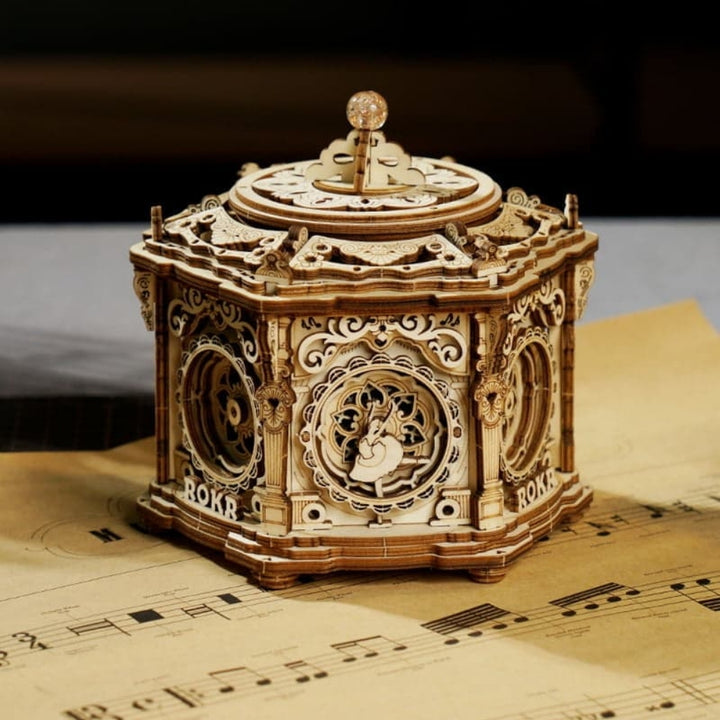 Wooden mechanical model on sheet music with a dark background