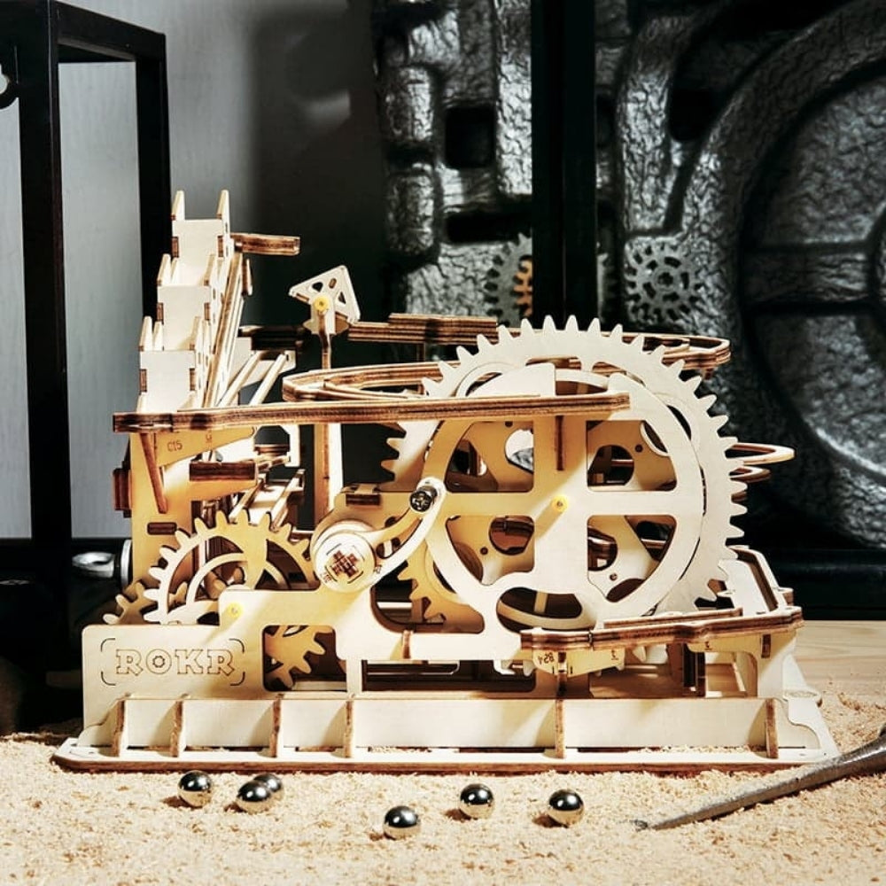 Wooden mechanical model with gears on a sandy surface
