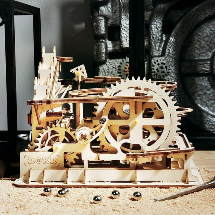 Wooden mechanical model with gears on a sandy surface
