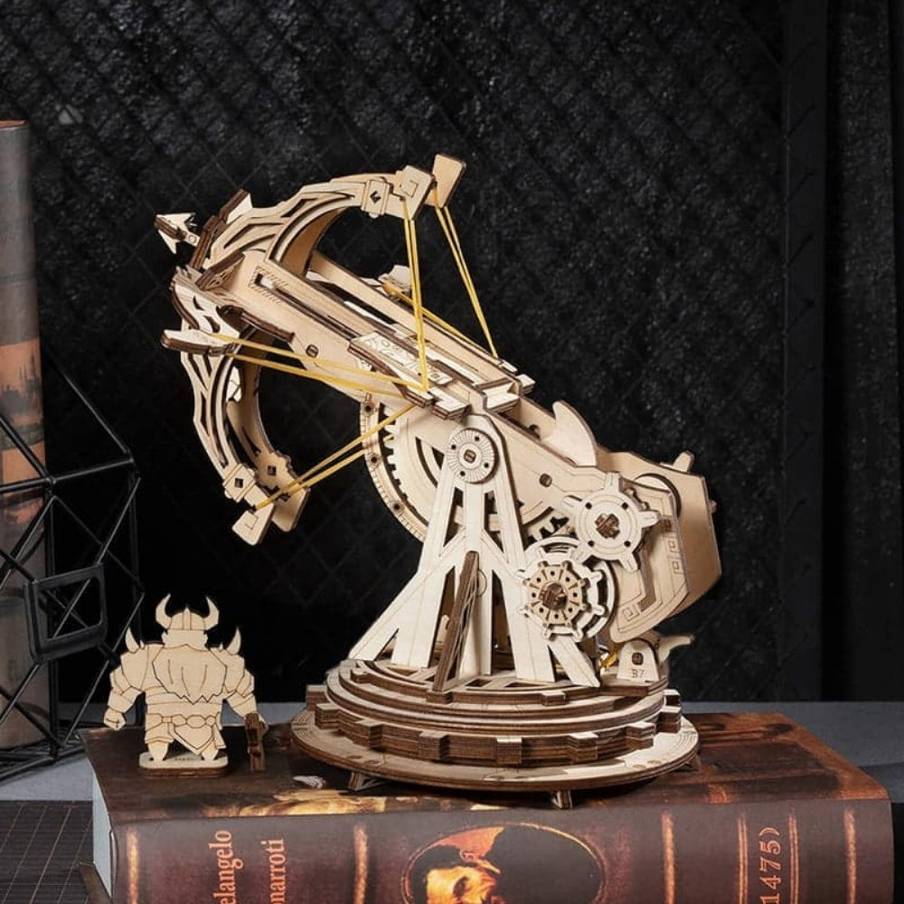 Wooden mechanical model on a book with a dark textured background