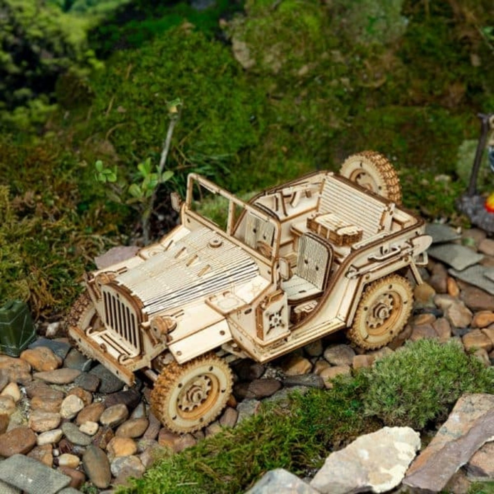 Wooden model of a jeep on a rocky and grassy terrain