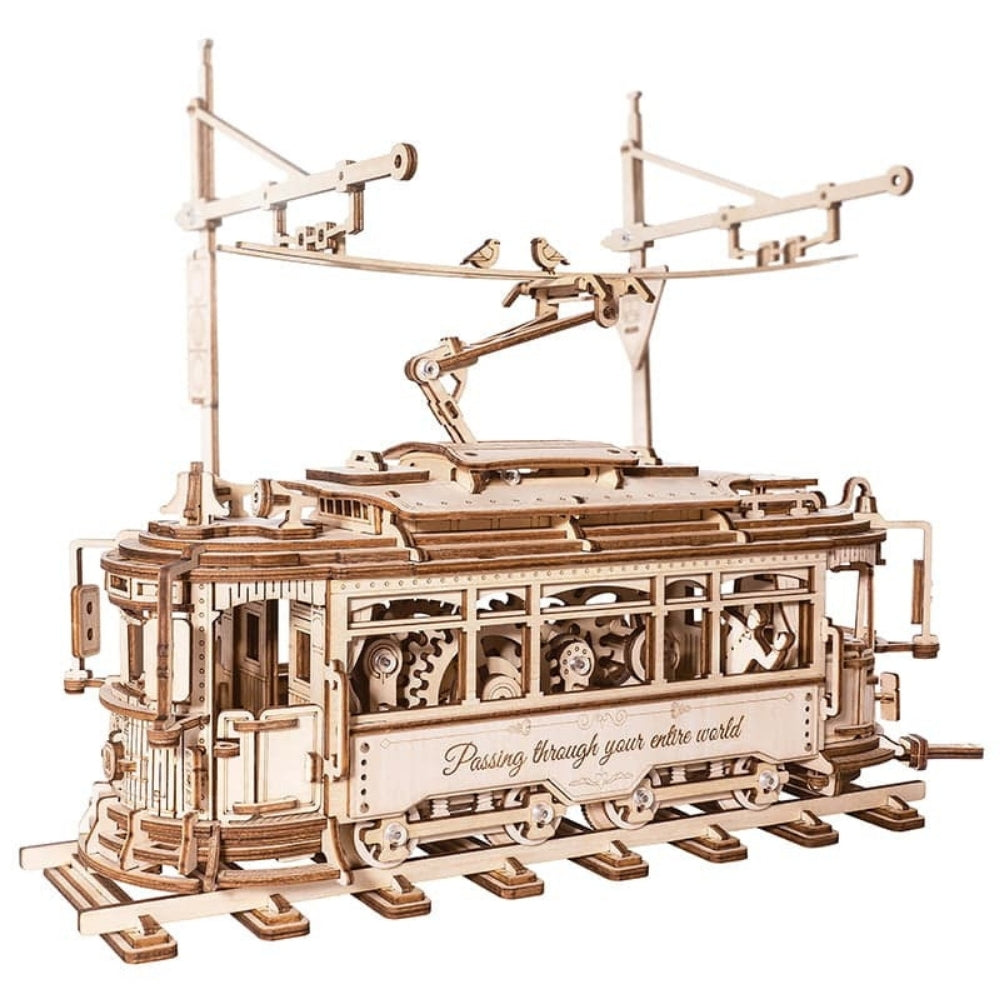 Wooden model of a tram with mechanical components on a white background
