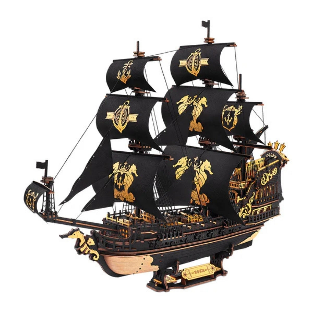 Model of a pirate ship with black sails and gold details on a white background