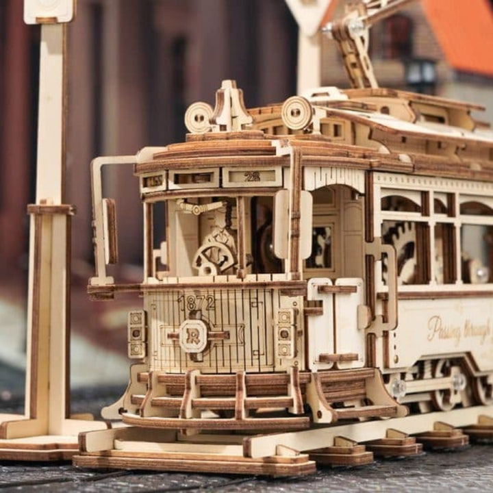 Wooden model of a vintage tram with intricate details on a blurred background