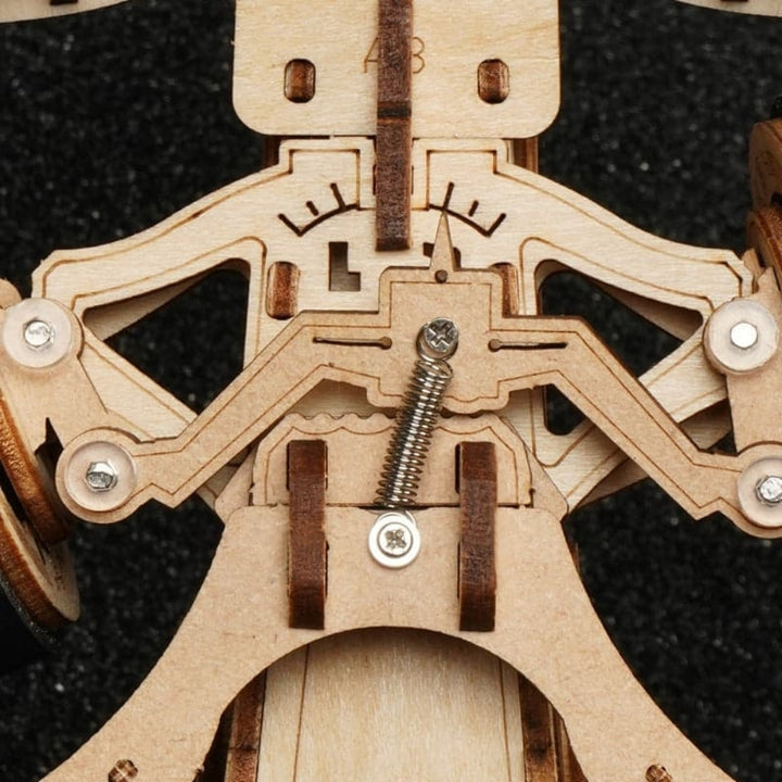 Close-up of a wooden mechanical model with intricate details on a black background