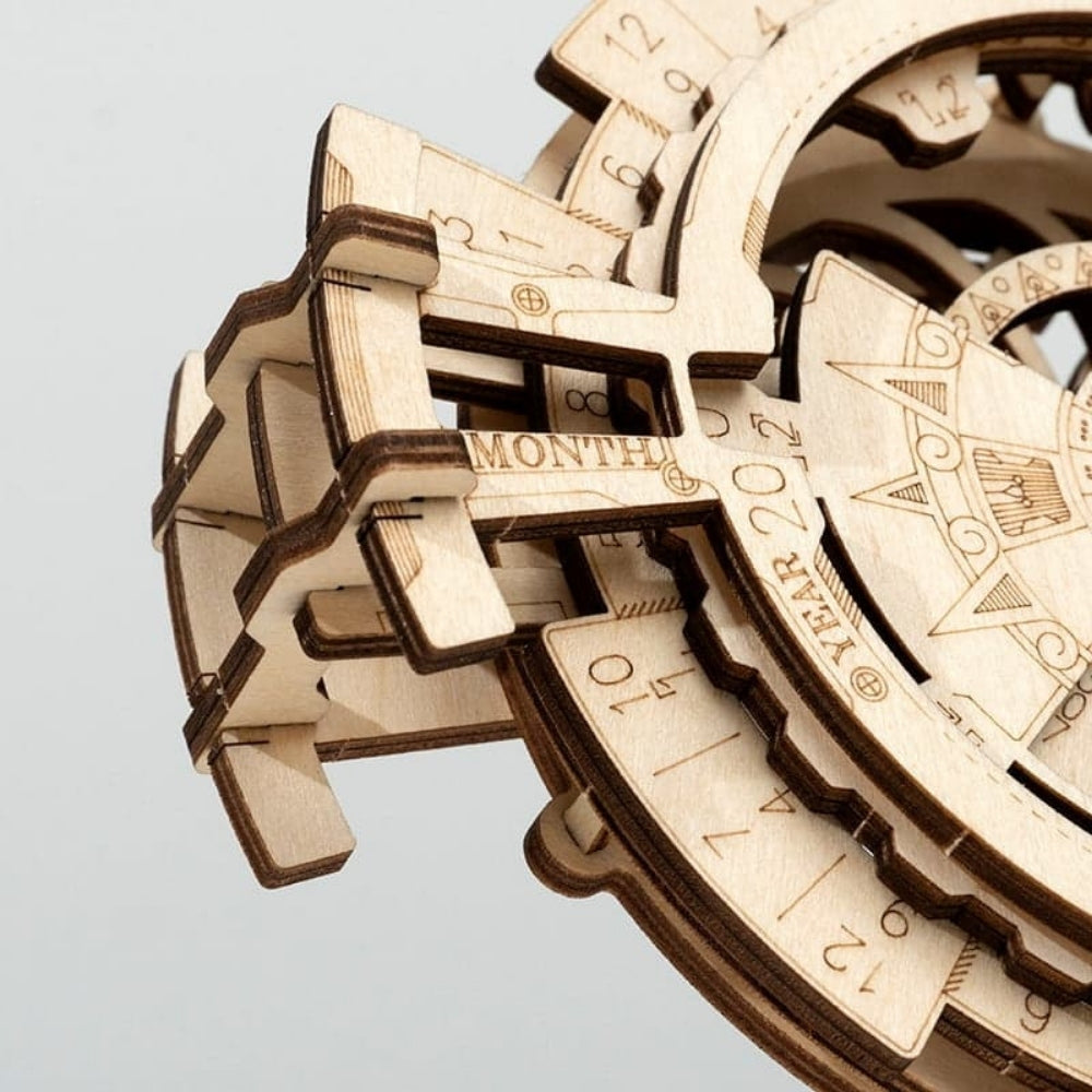 Wooden mechanical model of a calendar with intricate details on a light gray background