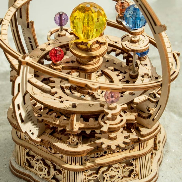 Wooden mechanical model with colorful spheres on a light background