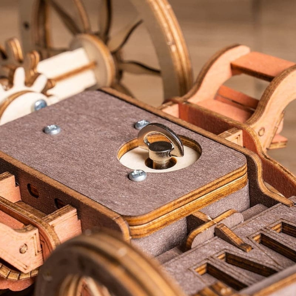 Close-up of a wooden mechanical model with gears and a platform.
