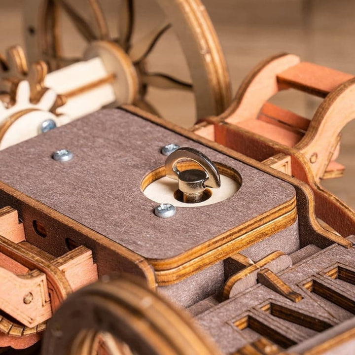 Close-up of a wooden mechanical model with gears and a platform.