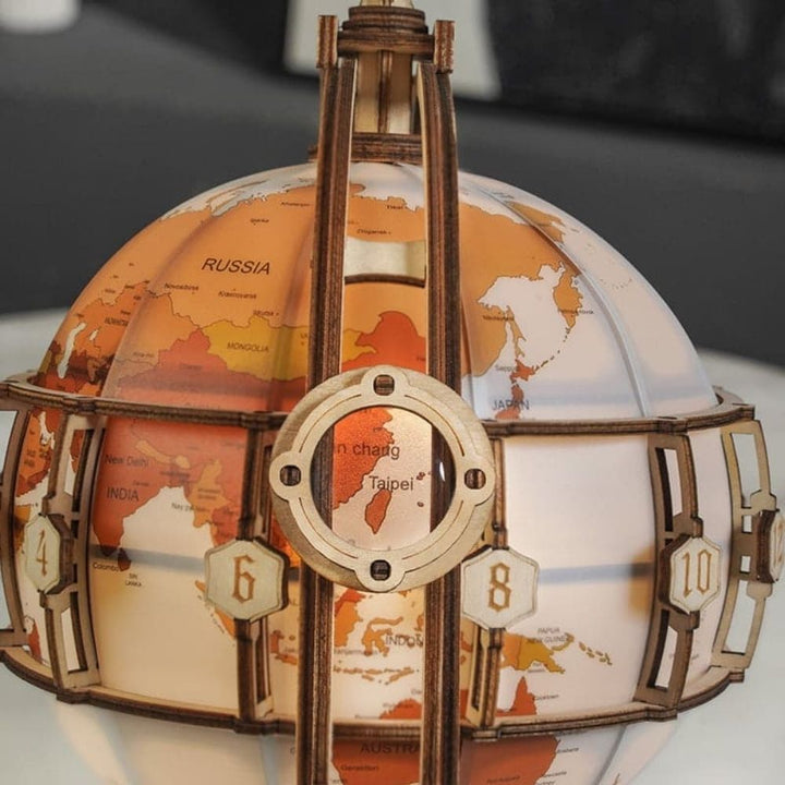Close-up of a decorative world globe with wooden accents on a blurred background