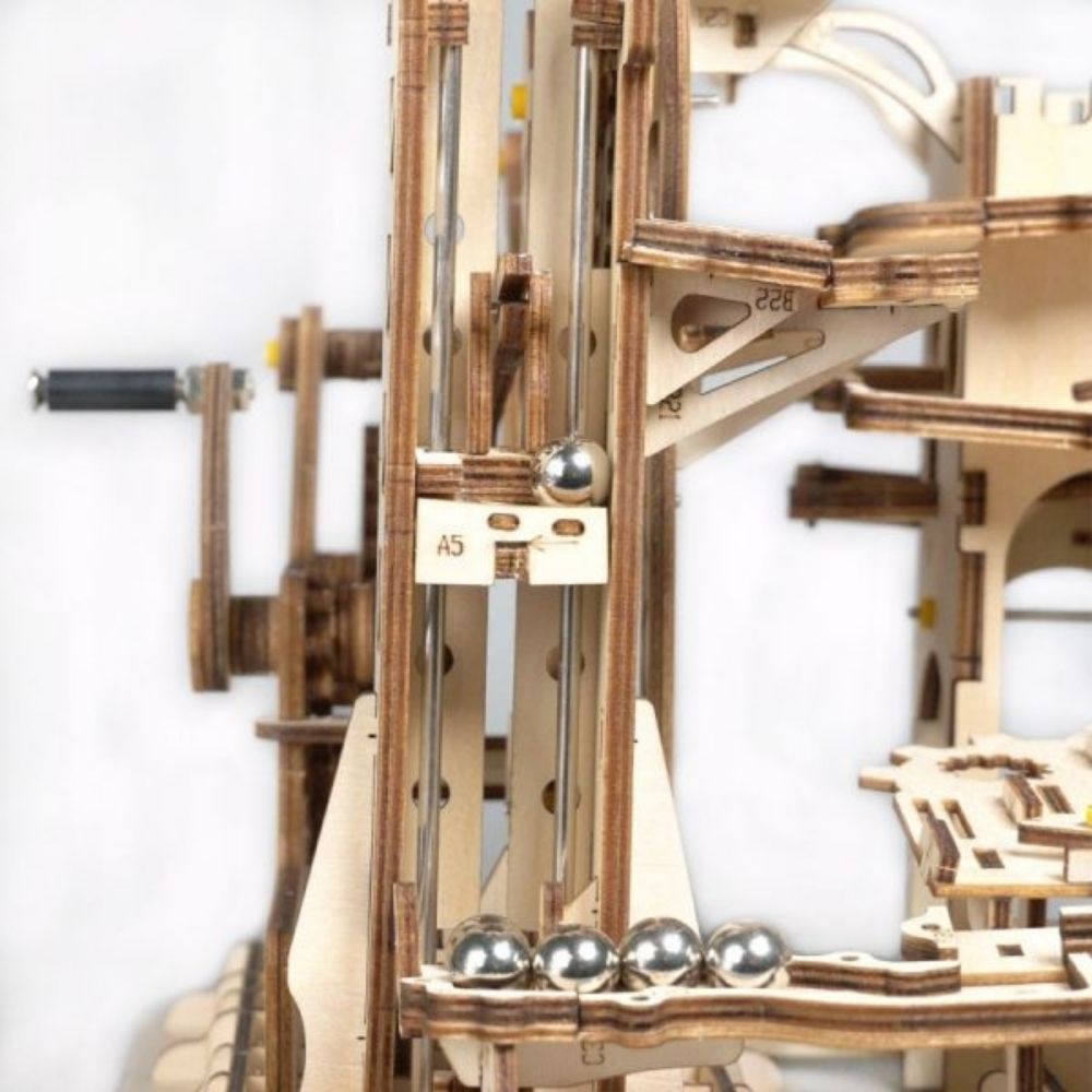 Wooden mechanical model with metal components on a white background