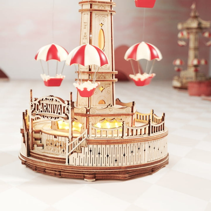Wooden model of a carnival ride with hot air balloons on a white background