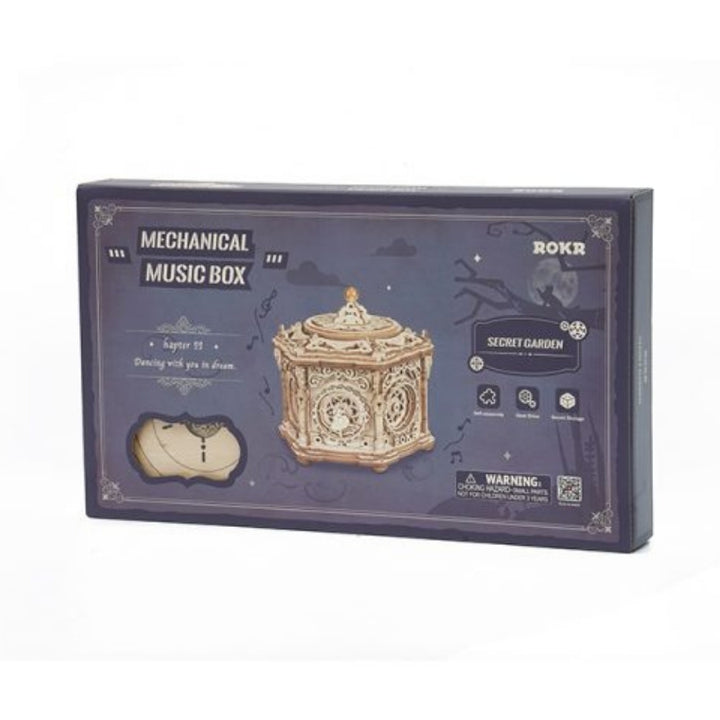 Boxed mechanical music box with intricate design on a white background